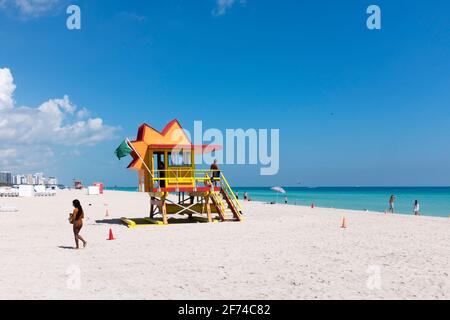 Ein Rettungsschwimmer in seinem Turm als perfektes Wetter und kristallklares Wasser begrüßen die Touristen an einem ruhigen Tag am Strand, in South Beach, Miami Beach, Florida Stockfoto