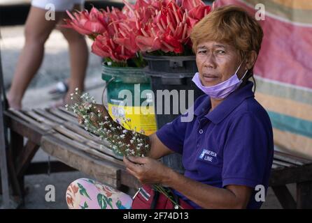 Eine Blumenverkäuferin mit Gesichtsmaske im Carbon Market, Cebu City, Philippinen Stockfoto