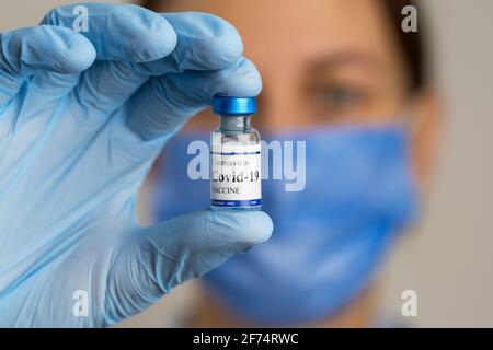Ärztin hält Spritze und Coronavirus-Impffläschchen. Stockfoto
