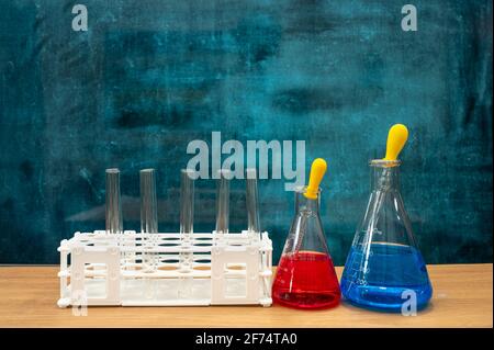 Werkzeuge für wissenschaftliche Experimente auf dem Schreibtisch. Leere Tafel. Bildungskonzept. Stockfoto