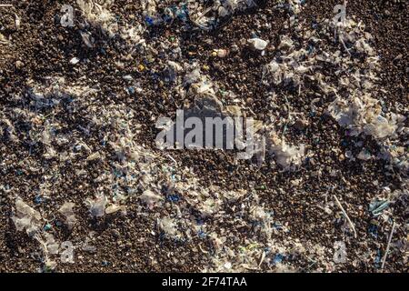 Kleine Kunststoffteile und Mikroplastik am Sandstrand Stockfoto
