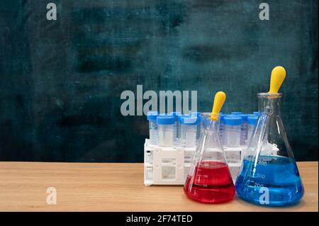 Werkzeuge für wissenschaftliche Experimente auf dem Schreibtisch. Leere Tafel. Bildungskonzept. Stockfoto