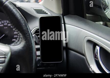 Handy auf dem Auto Luftauslass.Blank mit weißem Bildschirm.Mock up Smartphone im Auto. Stockfoto