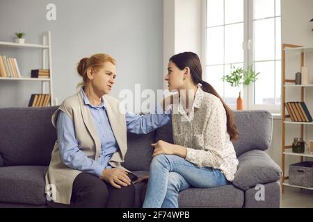 Ältere Mutter spricht mit ihrer jungen Tochter, gibt ihr Ratschläge und unterstützt sie Stockfoto
