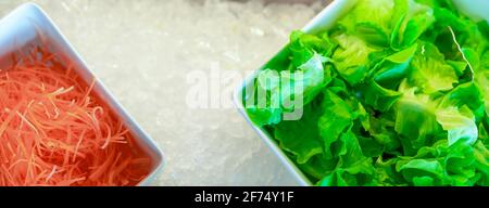 Salatbuffet im Restaurant. Salatbuffet zum Mittag- oder Abendessen. Gesunde Ernährung. Draufsicht frischer grüner Salat und Juliennekarotten in weißer Schüssel. Stockfoto