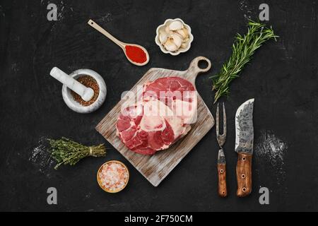 Blick von oben auf das Ossobuco-Steak mit rohem Rindfleisch und Gewürzen Stockfoto