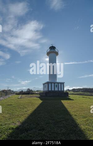 Schatten, der zum weißen Leuchtturm in Faro de Lastres führt In Asturien in Spanien unter wolkenlosem blauen Himmel am Tag Stockfoto