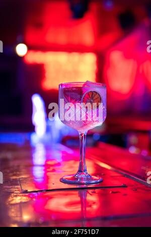 Gut ausgearbeiteter Gin Tonic Cocktail mit Erdbeeren und Rutsche dekoriert Von trockener Zitrone in der Bar Stockfoto