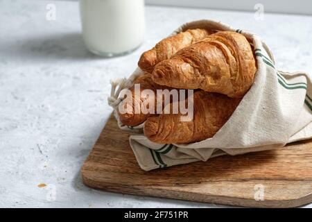 Leckere Croissants und eine Flasche Milch auf den Tisch gelegt Frühstück in der Küche Stockfoto
