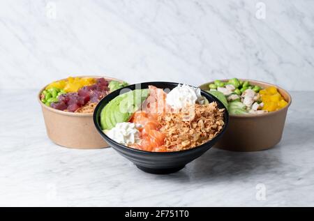 Schüsseln mit köstlichem Schälchen mit verschiedenen Zutaten Marmortisch in der Küche Stockfoto