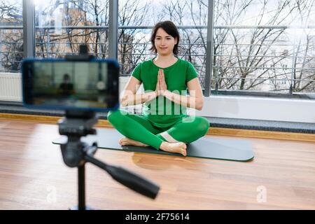 Frau machen Online-Yoga-Kurs mit dem Smartphone Stockfoto