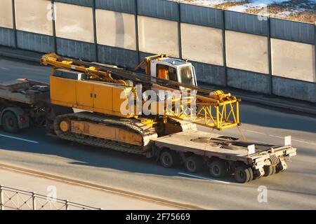 Transport eines Klappauslegerkrans auf einem LKW-Anhänger Stockfoto