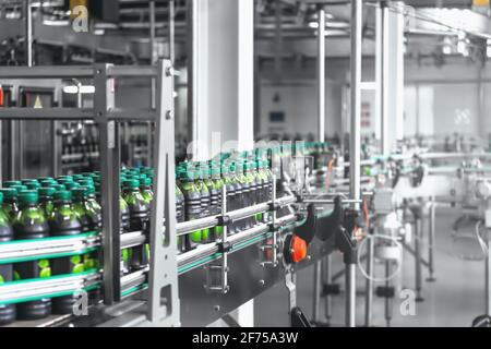 Industrielle Getränkefabrik mit automatisierter computergesteuerter Förderlinie oder Band und Kunststoffflaschen mit organischem Saft. Stockfoto