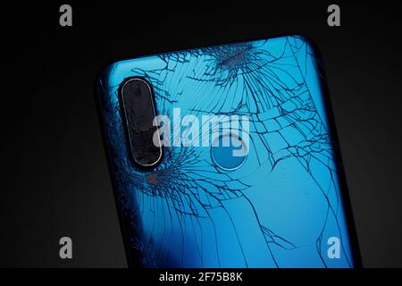 Die Rückseite eines defekten Mobiltelefons. Smartphone-Kamera beschädigt. Stockfoto