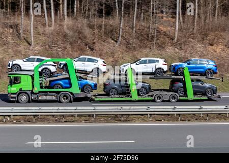 Adampol Scania Autotraster, der auf der Autobahn mit neuen Kia Sportage-Fahrzeugen beladen ist. Stockfoto