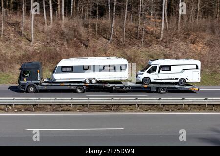 Braase Mercedes-Benz Atego PKW-LKW beladen mit neuen Camper auf der Autobahn. Stockfoto