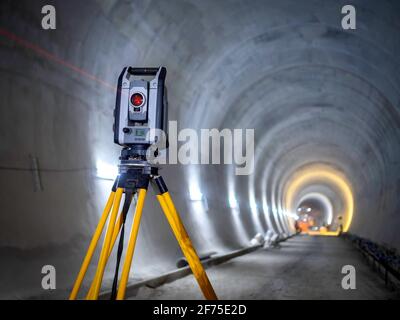 Theodolit bei unterirdischen Tunnelbauarbeiten. Baumessgeräte-Instrument auf Beton kreisförmigen Tunnel Hintergrund. Stockfoto