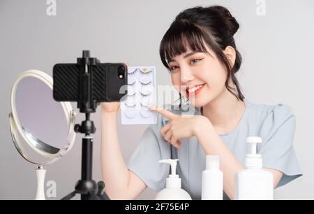 Junge asiatische Frau live Streaming zu lehren Make-up online Stockfoto