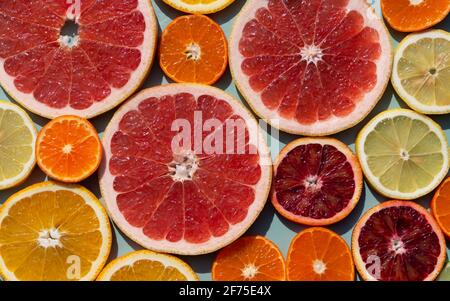 Moderner Hintergrund aus geschnittenen Zitrusfrüchten. Orange, Grapefruit, Limette, Mandarine, Zitrone. Bio-SPA-Kosmetik mit Orangenöl und Vitamin C. Stockfoto