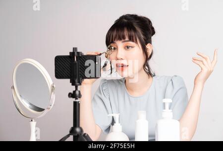 Junge asiatische Frau live Streaming zu lehren Make-up online Stockfoto