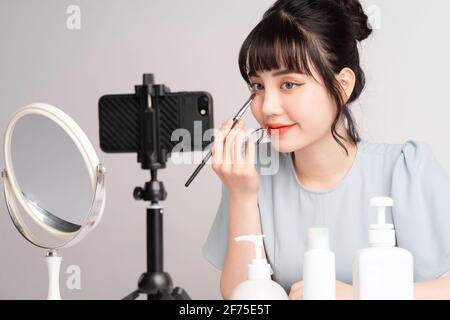 Junge asiatische Frau live Streaming zu lehren Make-up online Stockfoto