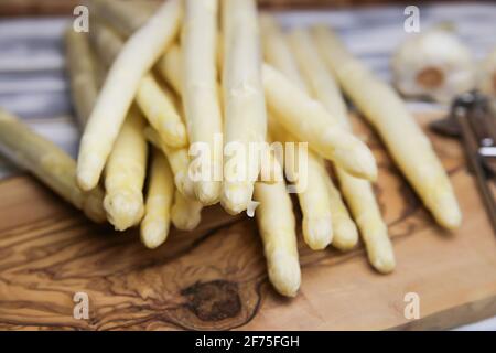 Nahaufnahme von isolierten, rohen, weißen, ungekochten Spargelspeeren Holztisch Stockfoto