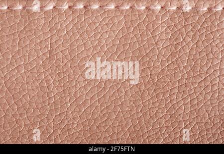 Lederstruktur mit Stichen. Oberfläche der beigefarbenen Kuhhaut Stockfoto