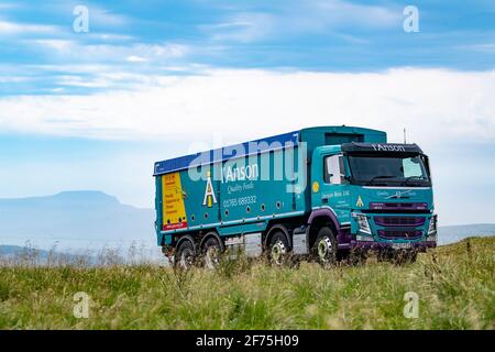 I'anson-Wagen mit Viehfutter, der auf einer schmalen Landstraße in North Yorkshire, Großbritannien, unterwegs ist. Stockfoto