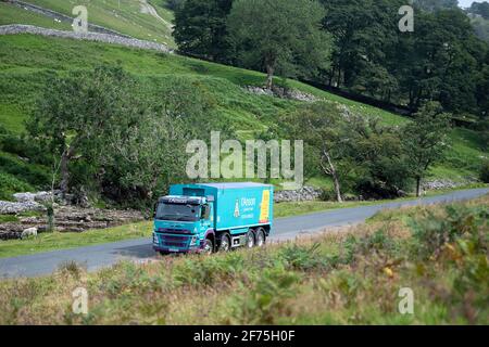 I'anson-Wagen mit Viehfutter, der auf einer schmalen Landstraße in North Yorkshire, Großbritannien, unterwegs ist. Stockfoto