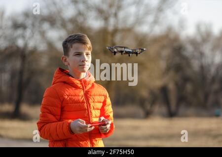 Teenager, der eine kleine Drohne im Park fliegt Stockfoto