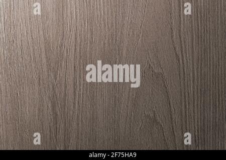 Grau ist ein brauner Holzhintergrund mit beigen Adern. Mitteldunkler strukturierter Längsschnitt. Stockfoto
