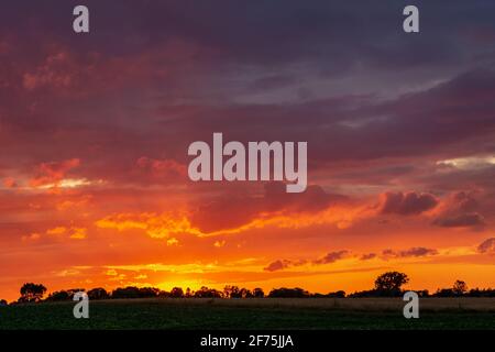 Farbenfroher Himmel und Wolken bei Sonnenuntergang über dem Horizont Stockfoto