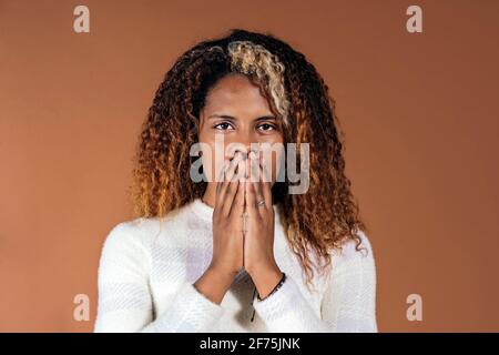 Stock Foto von schönen Frau mit lockigen Haaren Blick auf die Kamera während der Studioaufnahme. Stockfoto