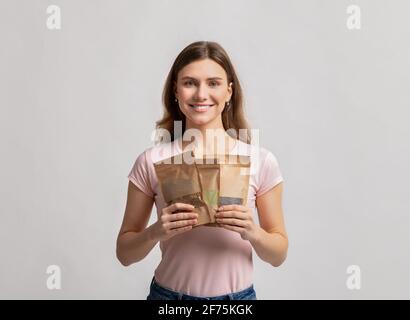 Eco Storage-Konzept. Lächelnde Millennial-Dame mit Doypack-Taschen und Gewichteinkäufen Stockfoto