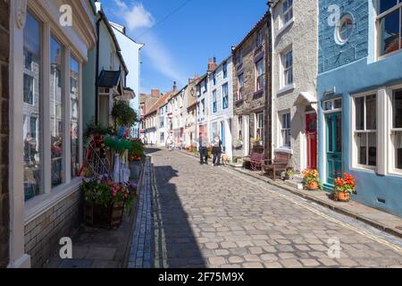 Farbenfrohe Cottages entlang der schmalen gepflasterten High Street in Staithes, einem malerischen Fischerdorf an der Küste von Yorkshire Stockfoto