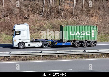 DAF XF LKW mit 20 Fuß UASC-Container auf der Autobahn. Stockfoto