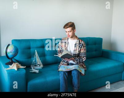 Reisekonzept. Der Junge träumt vom Reisen, während er den Globus benutzt. Stockfoto