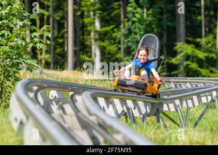 Junge auf Sommerrodelbahn Stockfoto