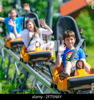 Familienspaß Rodeln im Sommer, hoch mit dem Lift ... runter mit der Rodel, ob in der Wanne oder auf der bahngeführten Achterbahn. Stockfoto