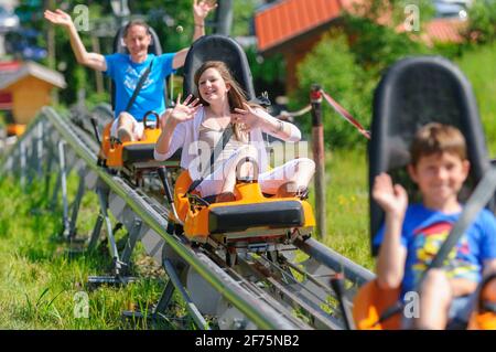 Familienspaß Rodeln im Sommer, hoch mit dem Lift ... runter mit der Rodel, ob in der Wanne oder auf der bahngeführten Achterbahn. Stockfoto