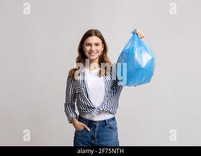 Porträt Der Lächelnden Millennial Lady Trägt Blauen Kunststoff Abfallbeutel Stockfoto
