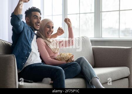 Emotionale arabische Paar Fußballfans beobachten Spiel Stockfoto