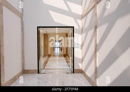 Langer leerer Korridor in hellen Farben mit Sonnenlicht und Schatten. Stockfoto