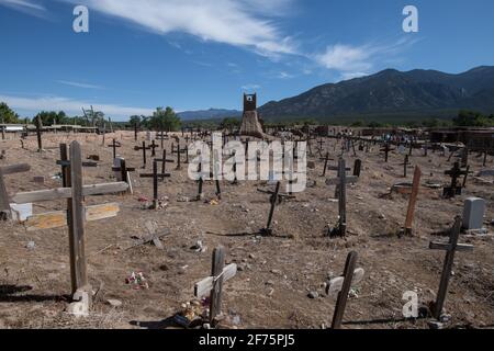 Der historische Taos Pueblo Friedhof in New Mexico mit verwitterten Holzkreuzen, die die Gräber der indianischen Gemeinde markieren. Stockfoto