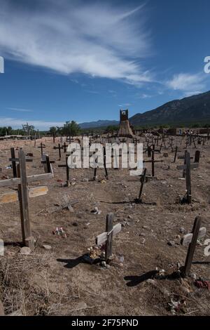 Der historische Taos Pueblo Friedhof in New Mexico mit verwitterten Holzkreuzen, die die Gräber der indianischen Gemeinde markieren. Stockfoto