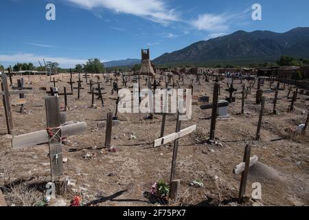 Der historische Taos Pueblo Friedhof in New Mexico mit verwitterten Holzkreuzen, die die Gräber der indianischen Gemeinde markieren. Stockfoto