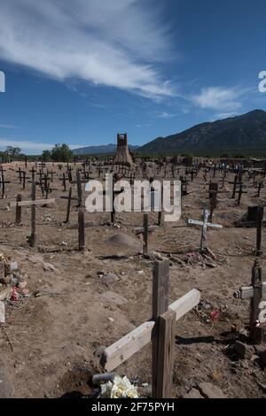 Der historische Taos Pueblo Friedhof in New Mexico mit verwitterten Holzkreuzen, die die Gräber der indianischen Gemeinde markieren. Stockfoto