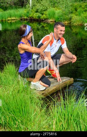 Junge Menschen joggen auf einem Waldweg, gemeinsames Lauftraining für zwei. Stockfoto