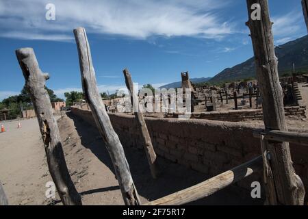 Der historische Taos Pueblo Friedhof in New Mexico mit verwitterten Holzkreuzen, die die Gräber der indianischen Gemeinde markieren. Stockfoto