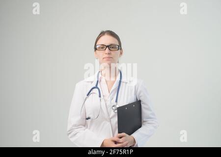 Portrait einer attraktiven jungen Frau Doktor im weißen Mantel. Stockfoto